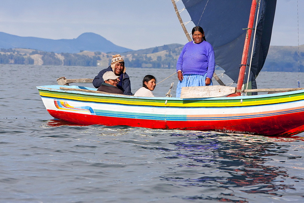 Family on board a sailing boat on Lake Titicaca, La Paz Department, Bolivia