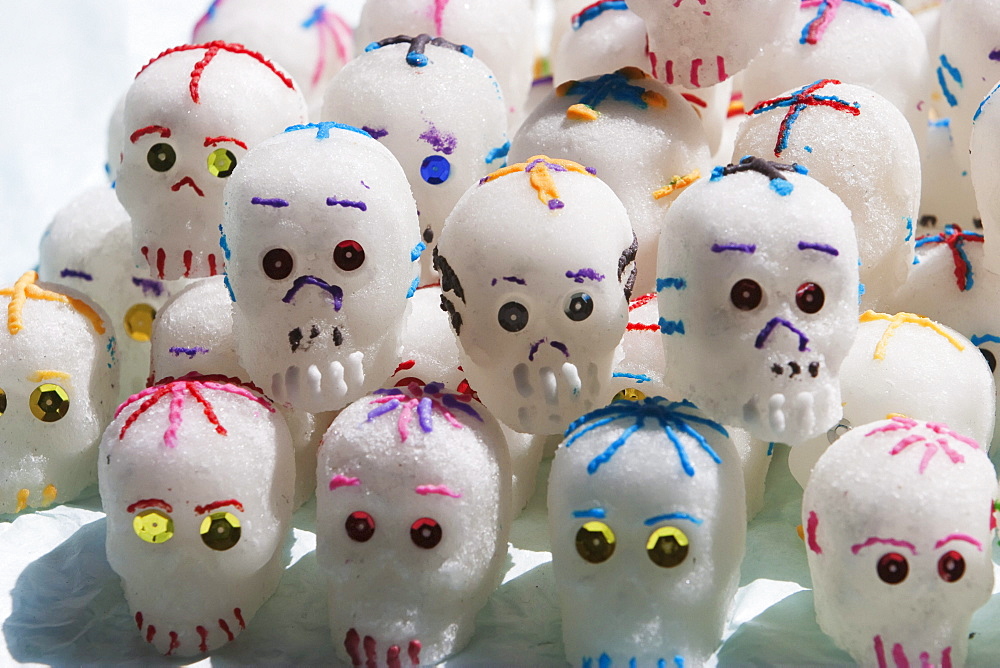 Calaveras (skulls) made from sugar paste for the celebration of Dia de los Muertos, the Day of the Dead in Putzcuaro. These skulls are decorated with flowers and scrolls of coloured icing and metallic coloured foils., Michoacun, Mexico