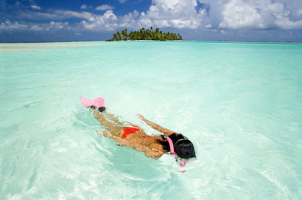 French Polynesia, Woman snorkeling in tropical ocean water.