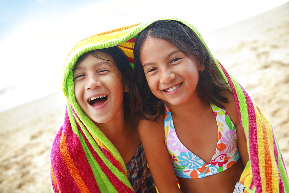 Hawaii, Oahu, Two young girls wrapped in a colorful towel.