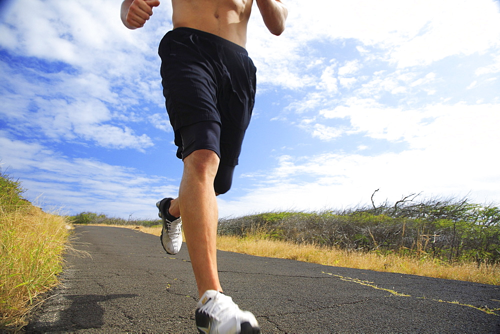 Hawaii, Oahu, Makapu'u, Athletic male running along the makapuu hiking trail, closeup of feet