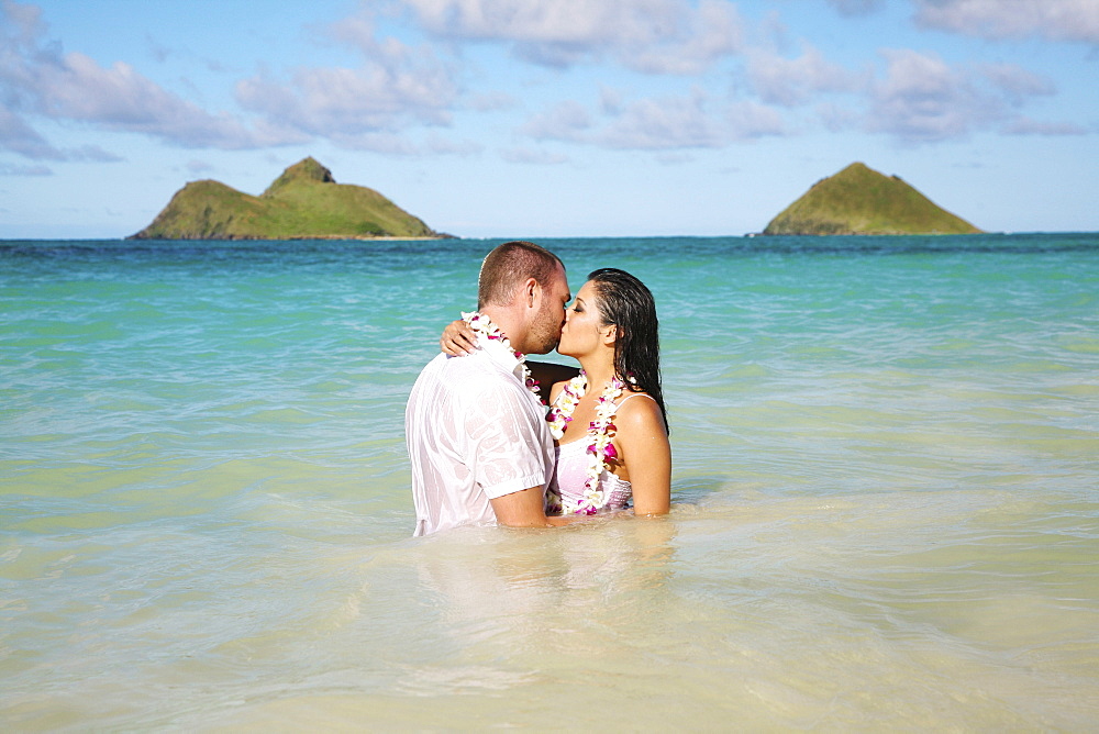 Oahu, Hawaii, Lanikai, Young couple both holding eachother and kissing.