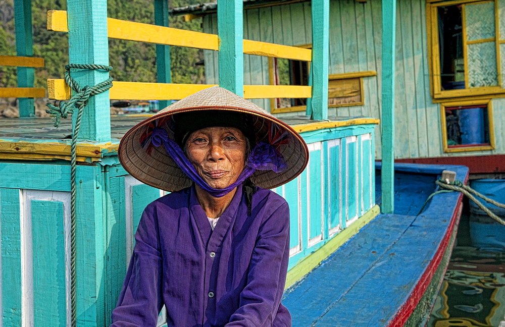 South East Asia, Vietnam, Ha Long Bay, Portrait of a  Vietnamese woman sitting on docked fishing boat.