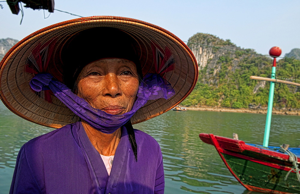 South East Asia, Vietnam, Ha Long Bay, Portrait of a  Vietnamese woman, Harbor in background.