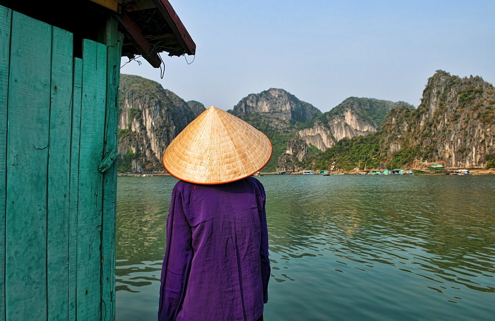 South East Asia, Vietnam, Ha Long Bay, Portrait of a  Vietnamese woman from behind, Harbor in background.