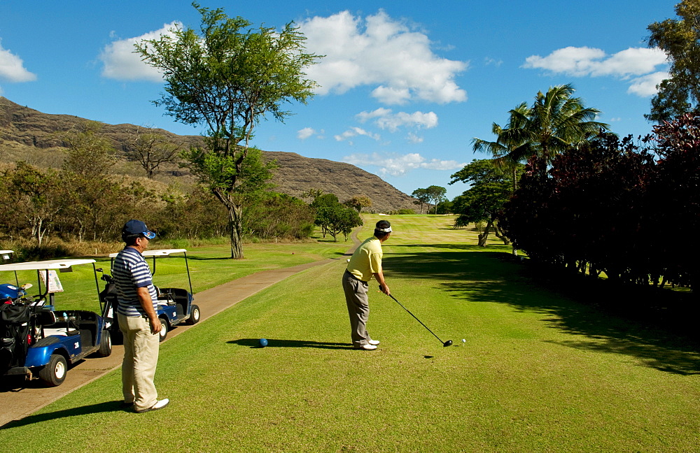 Hawaii, Oahu, Waianae, Makaha Resort, Two Japanese men play the 15th hole.