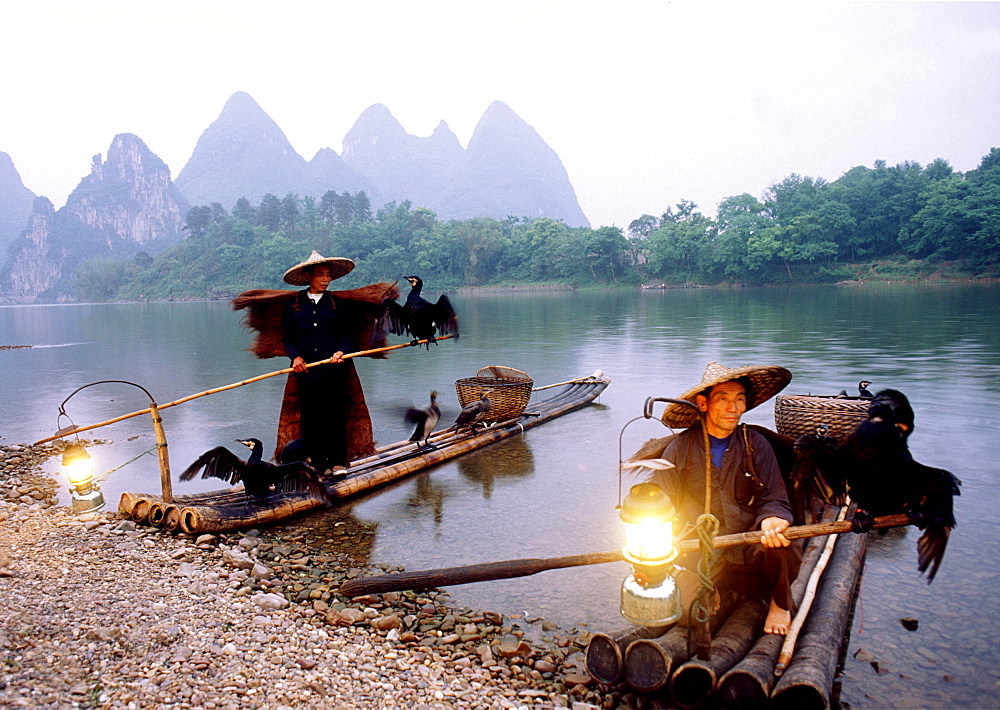 China, Li River, near Yangshou, Local men floating on bamboo raft.