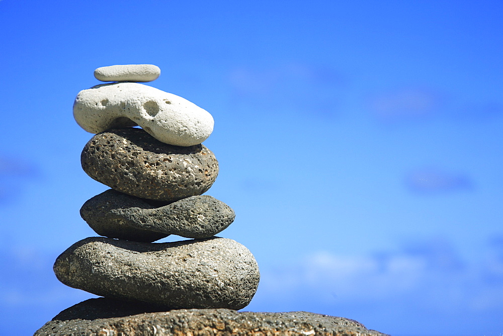 Hawaii, Oahu, Spa element of rocks stacked up against a blue sky.