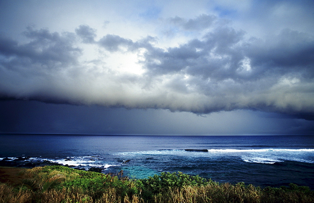 Hawaii, Maui, North Shore, Storm front clouds overlooking ocean from hillside.