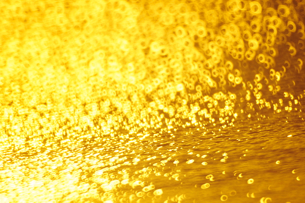 Closeup of golden shimmering reflections off water.