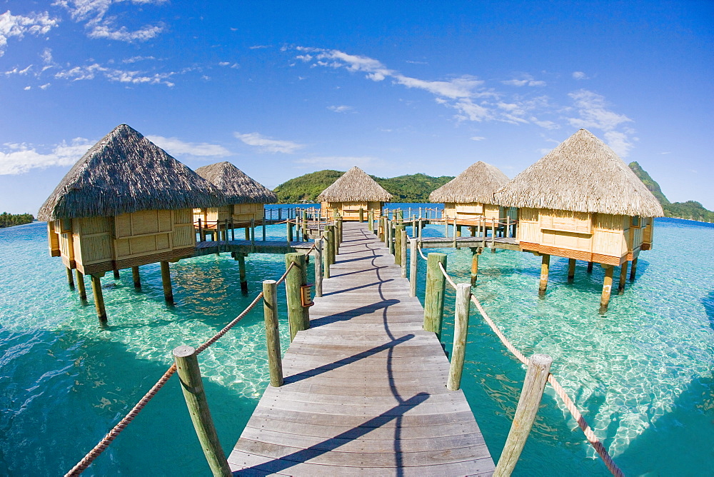 French Polynesia, Pearl Resort, Bungalows over beautiful turquoise ocean.