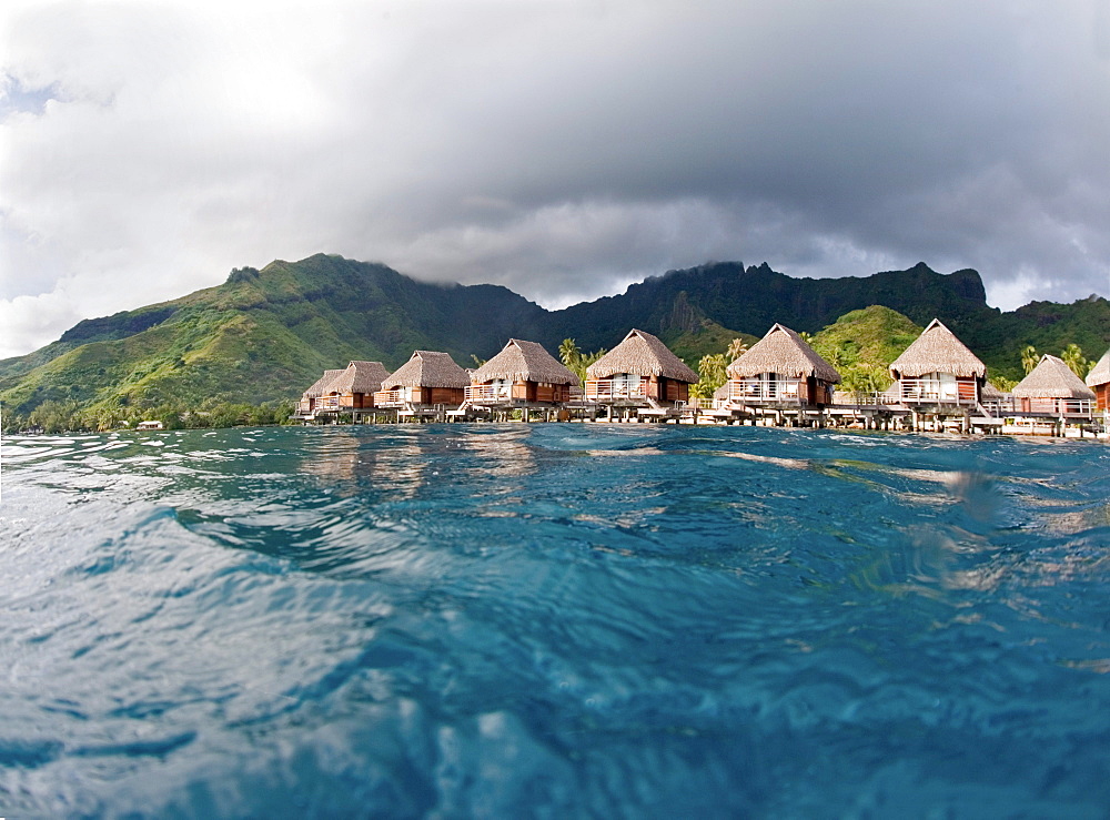 French Polynesia, Moorea Lagoon Resort, Bungalows over beautiful turquoise ocean.