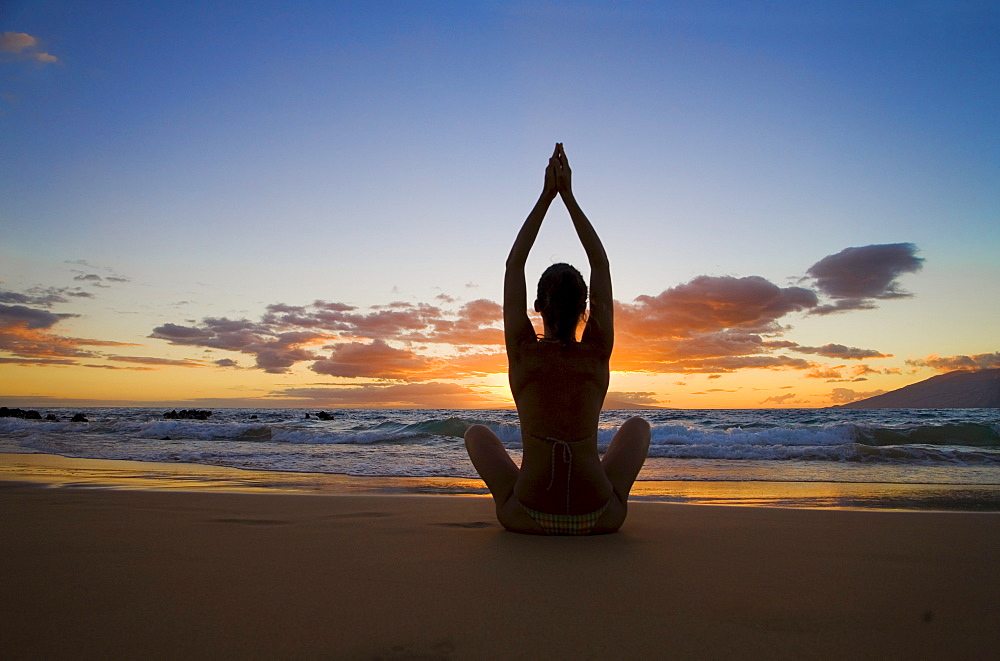 Hawaii, Maui, Silhouette of beautiful girl doing yoga on the beach.