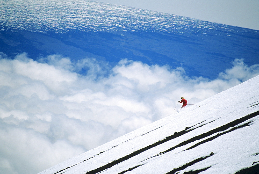 Hawaii, Big Island, Mauna Kea, Woman skiing downhill at high elevation.