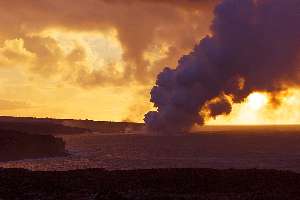 Hawaii, Big Island, Kalapana, Steam cloud from lava entering Pacific Ocean from Kilauea at sunset.