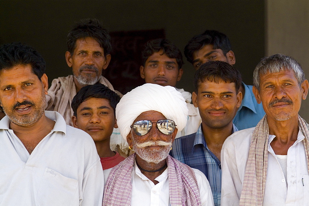 India, Rajasthan, near Ranthambore,  old Hindu men, one wearing western sunglasses, in small village of Charu.