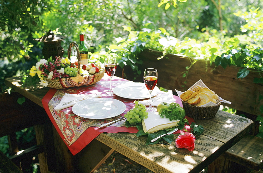 Alfresco lunch on wooden table in outdoor setting.