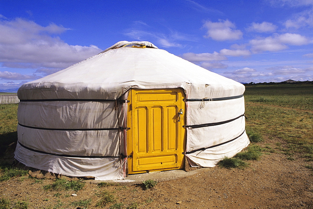 Mongolia, Ger Ranch, Traditional Nomadic home with yellow door, flat grassy countryside.