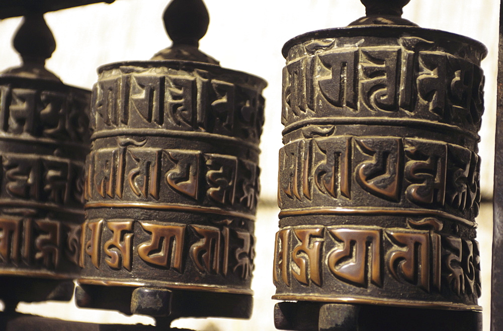 Nepal, Kathmandu, Swayambhunath Temple, closeup of prayer wheels with carvings.