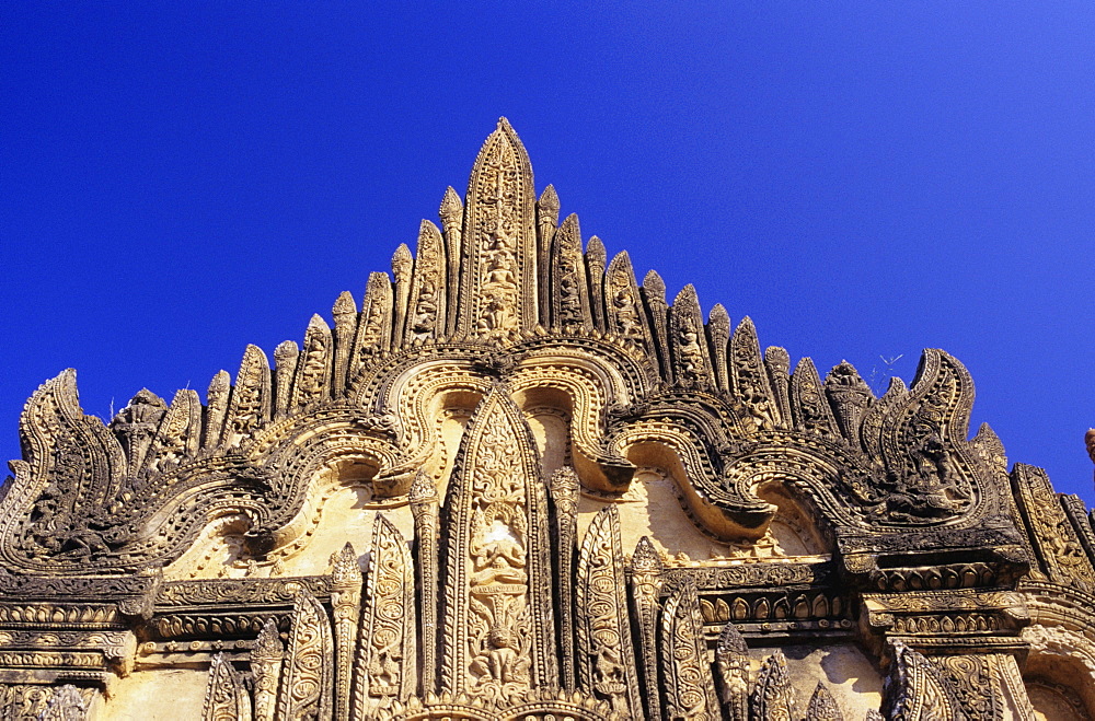 Burma (Myanmar), Bagan, Tayyukpye Temple, detail of Stucco Reliefs on top, blue sky.