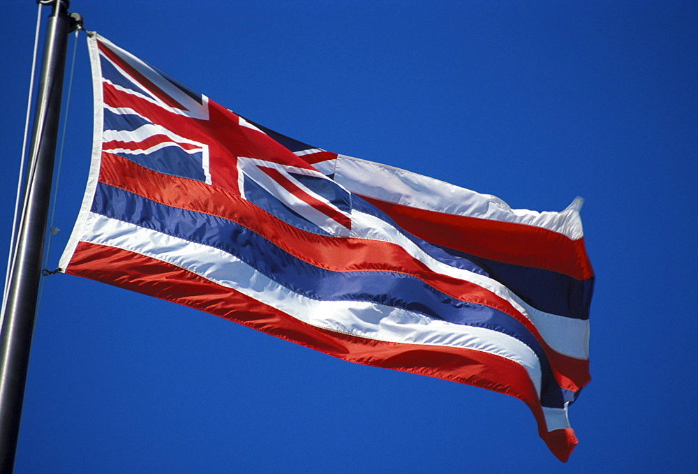 Hawaii, Hawaiian Flag blowing in the wind against deep blue sky