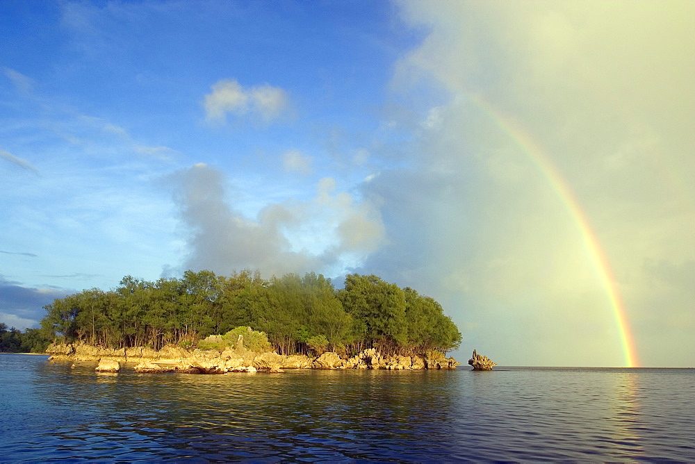 Micronesia, Palua, Rainstorm approaches a small island, rainbow overhead.