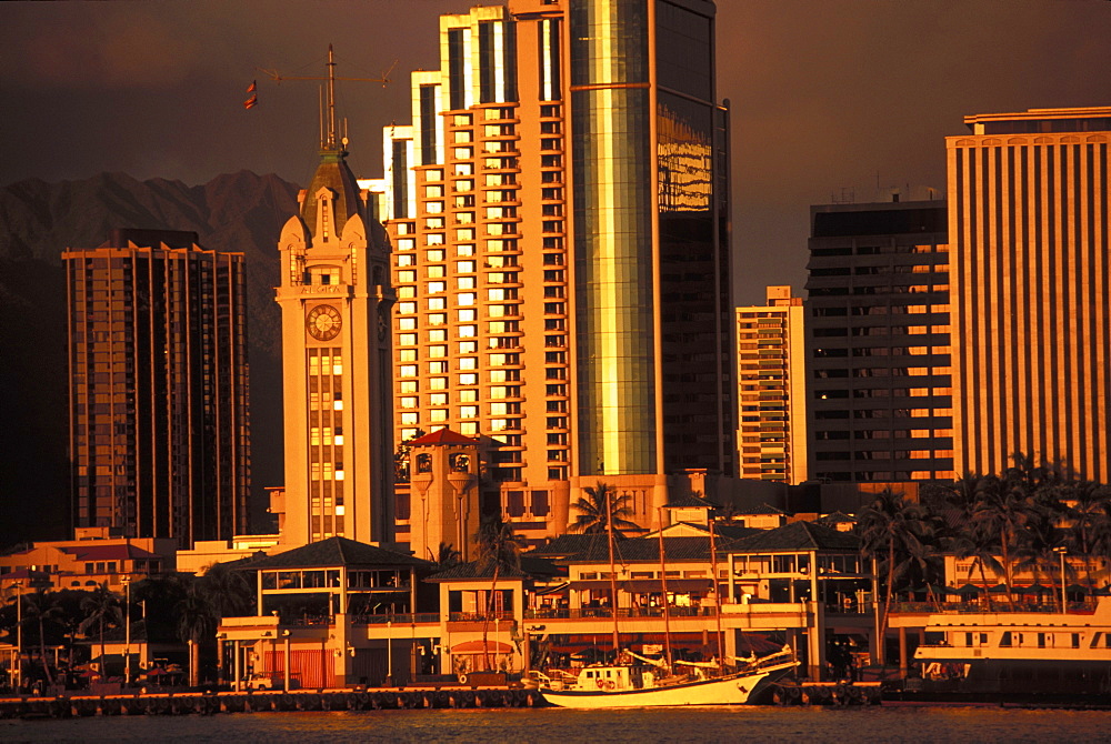 Hawaii, Oahu, Aloha Tower, Honolulu harbor, and downtown cast in a golden hue