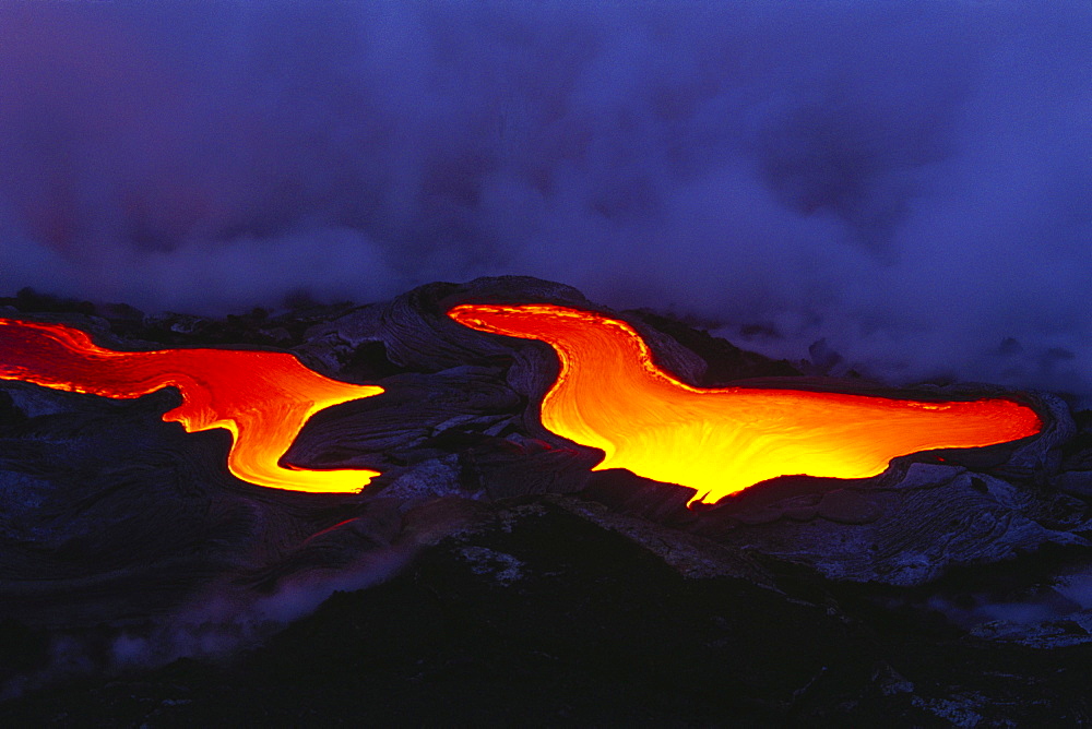 Hawaii, Big Island, Hawaii Volcanoes National Park, Pahoehoe glowing lava flow, river like smoke in background.