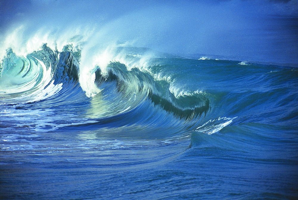 Rough seas, large curling waves and cloudy sky