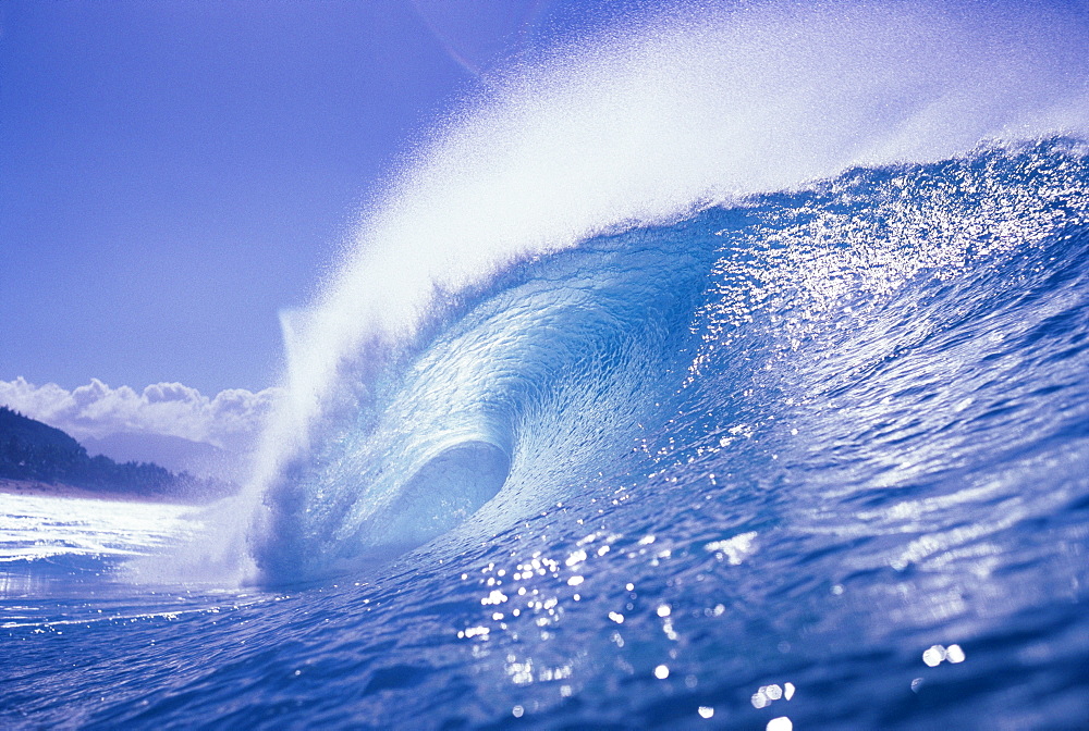 Large curling glassy wave, slight glimpse of land.