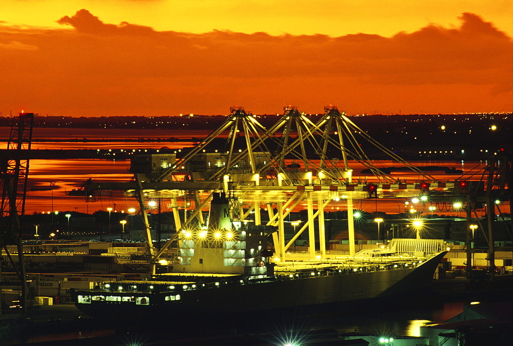 Hawaii, Oahu, Bright lights of a container ship at dusk in Honolulu Harbor.