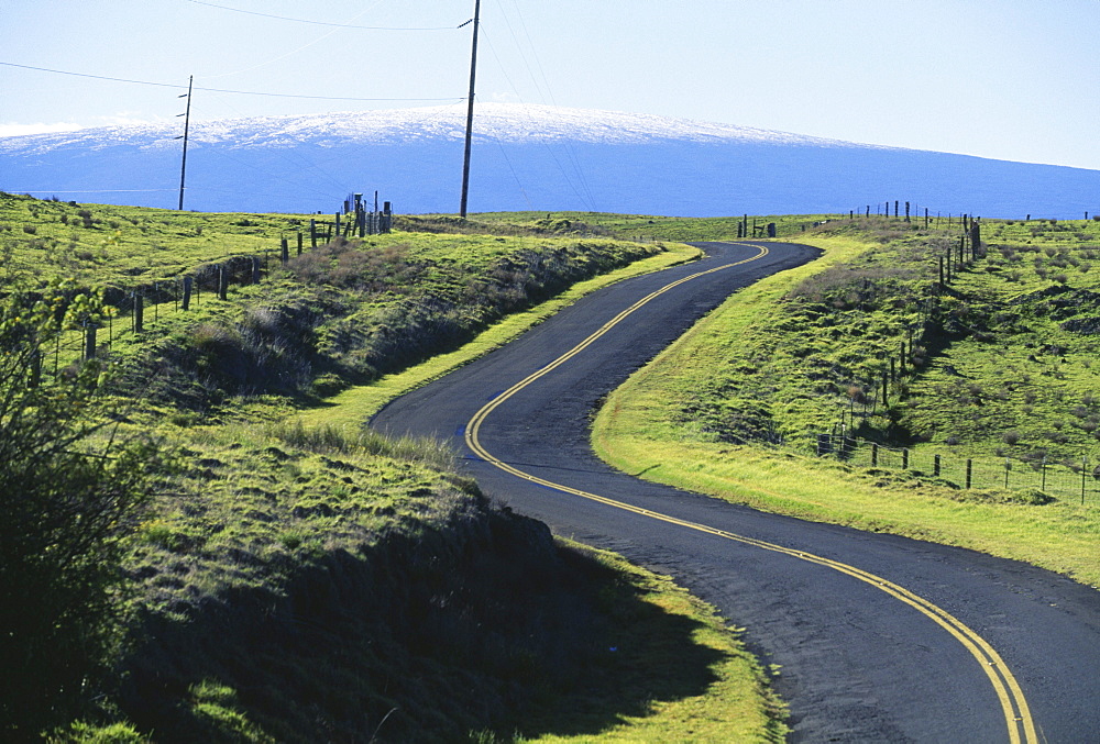 Hawaii, Big Island, Saddle Road curves it's way towards snowcapped Mauna Loa.