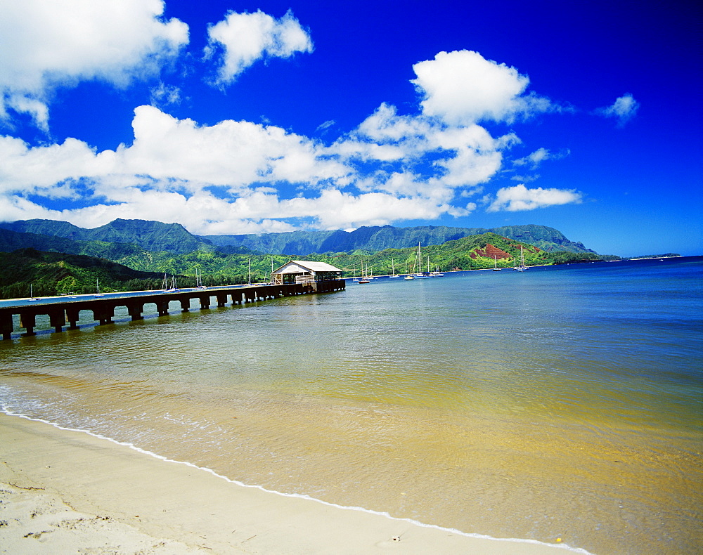 Hawaii, Kauai, Hanalei Bay with pier walkway, sailboats anchored in background