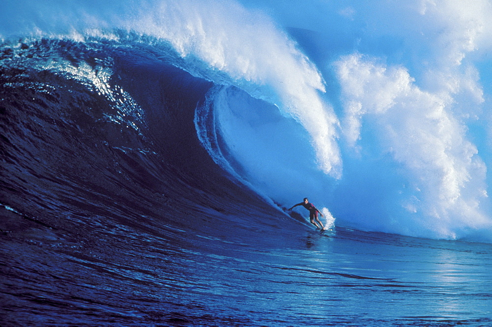 Hawaii, Maui, North Shore, Buzzy Kerbox surfs huge wave crashing behind Peahi AKA Jaws