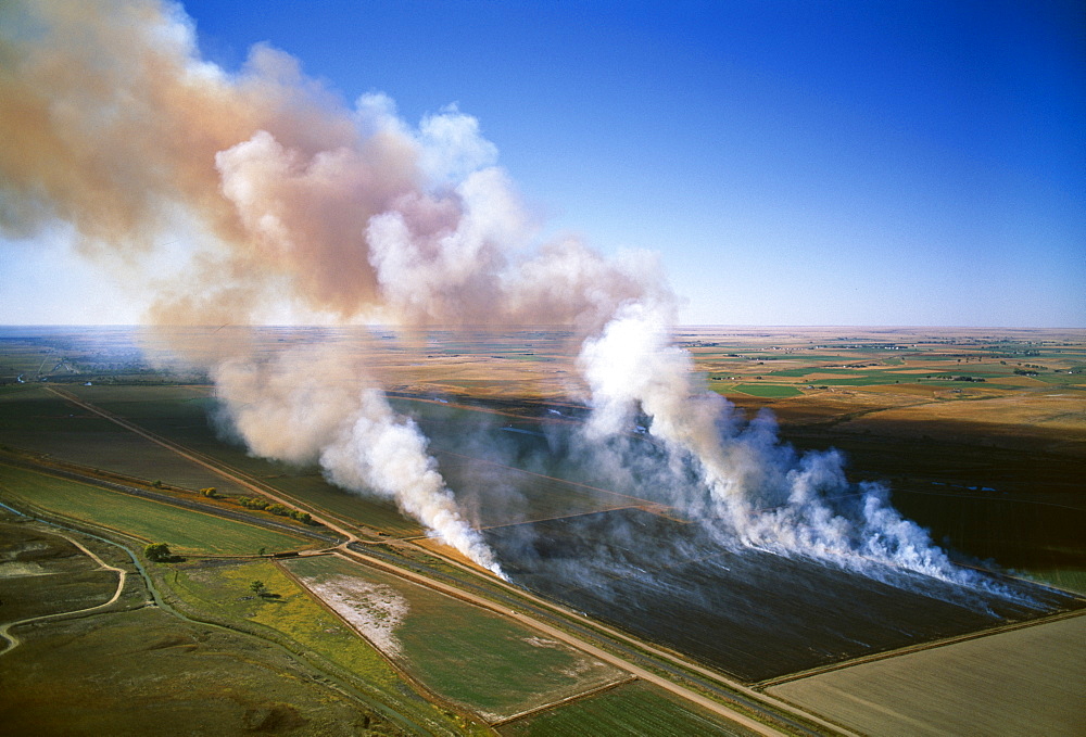 Agriculture - Aerial view of a field of grain stubble being burned / near Lamar, Colorado, USA.