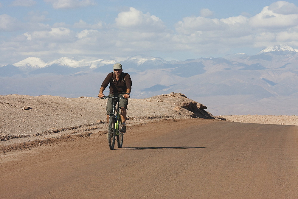 Man On A Mountain Bike Travelling Through The Valle De La Luna (Moon Valley), San Pedro De Atacama, Antofagasta Region, Chile