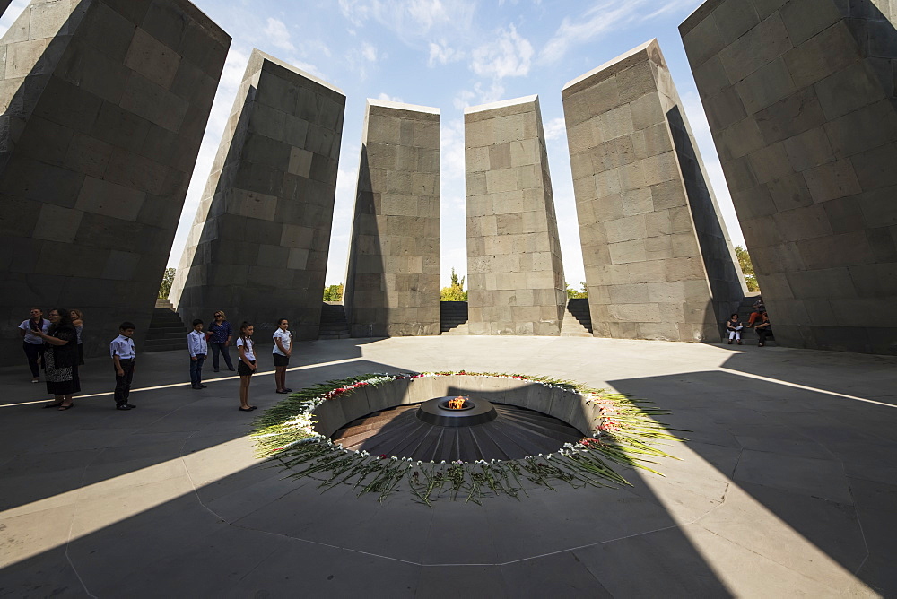 School children standing by the eternal flame dedicated to the 1.5 million people killed during the Armenian Genocide in the Armenian Genocide memorial complex on Tsitsernakaberd hill, Yerevan, Armenia 