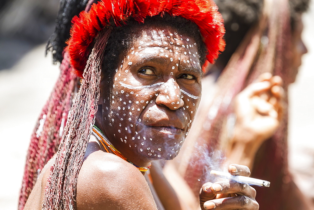 Dani woman smoking a cigarette, Obia Village, Baliem Valley, Central Highlands of Western New Guinea, Papua, Indonesia