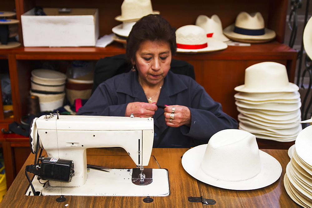 Woman sewing the black brim on to a panama hat at the Barranco Panama Hat Factory, Cuenca, Azuay, Ecuador