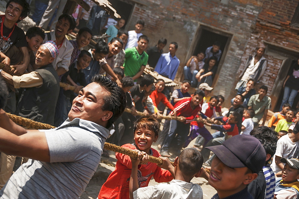 Young people pulling the strings to hoist the mast at the traditional Bisket Jatra Festival in Napalese New Year, Bhaktapur, Nepal