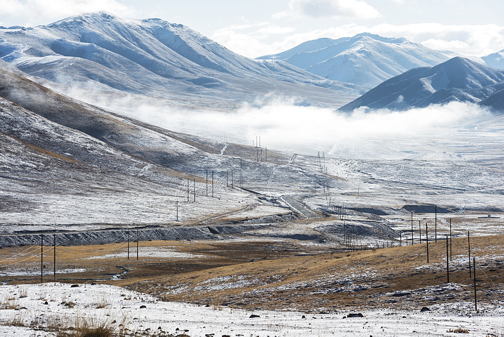 Electrical lines and poles stretch out across Tibetan mountains, Tibet