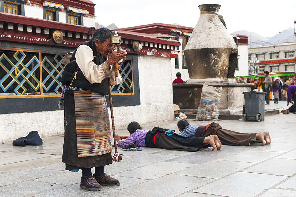 A old woman prays in front of Jokhang Temple, Lhasa, Tibet, China