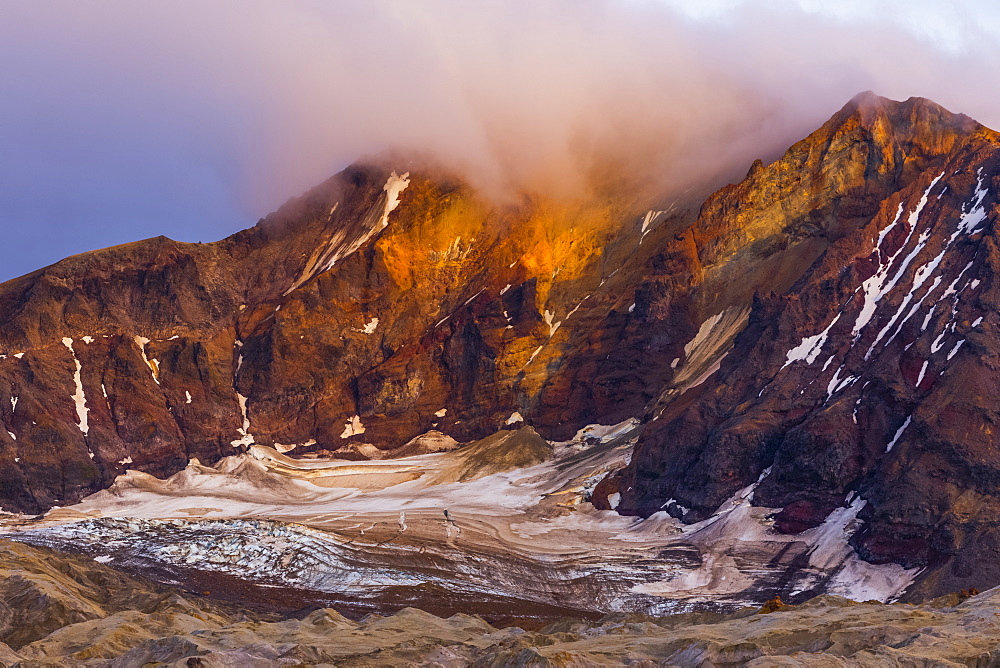 Trident Volcano rises above the ash-covered Knife Creek Glaciers at sunset in Katmai National Park; Alaska, United States of America