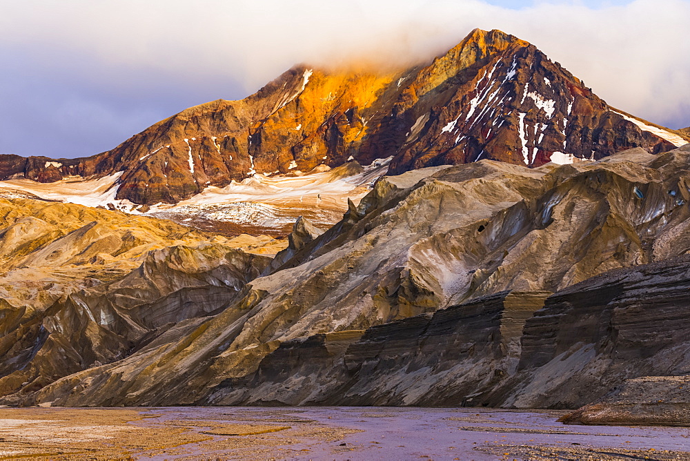 The eastern peak of Trident Volcano rises above the ash-covered Knife Creek Glaciers at sunset in Katmai National Park; Alaska, United States of America