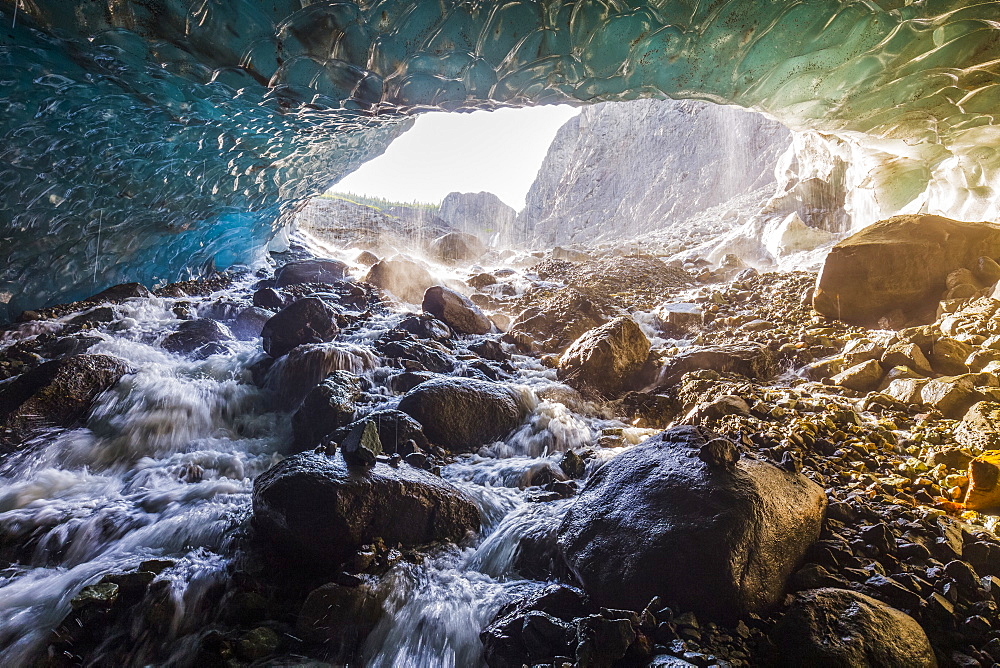 Water cascades over rocks inside a cave beneath the ice of Root Glacier in Wrangell-St. Elias National Park; Alaska, United States of America