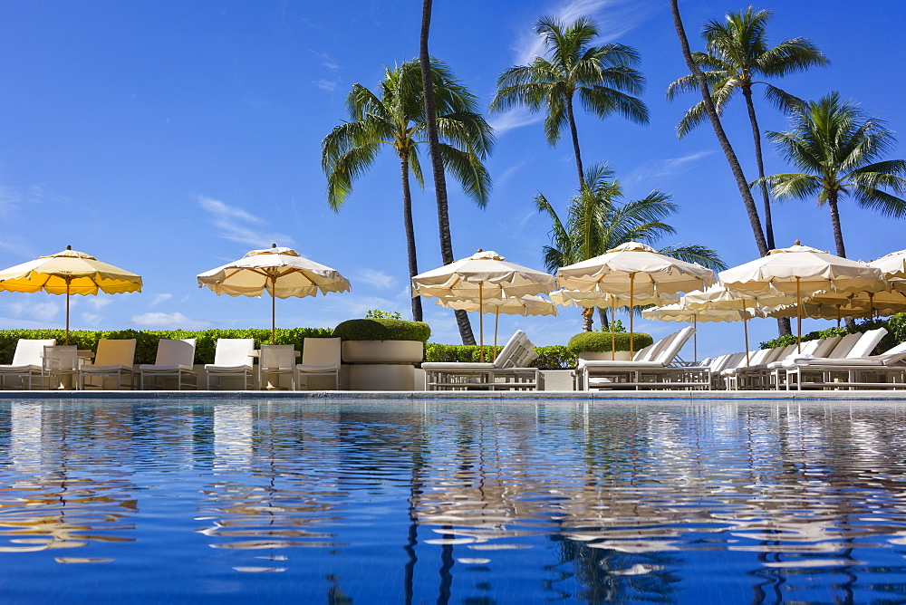 Halekalani Pool at Waikiki with palm trees and umbrellas reflected in the water, Waikiki, Oahu, Hawaii, United States of America