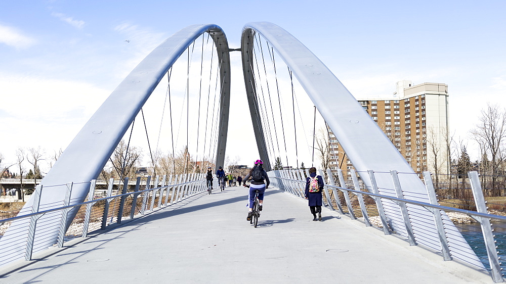 Pedestrians and cyclists going across a bridge over the Bow River, Calgary, Alberta, Canada