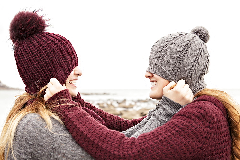 Two friends playing on the beach wearing knit hats and scarves, Woodbine Beach, Toronto, Ontario, Canada