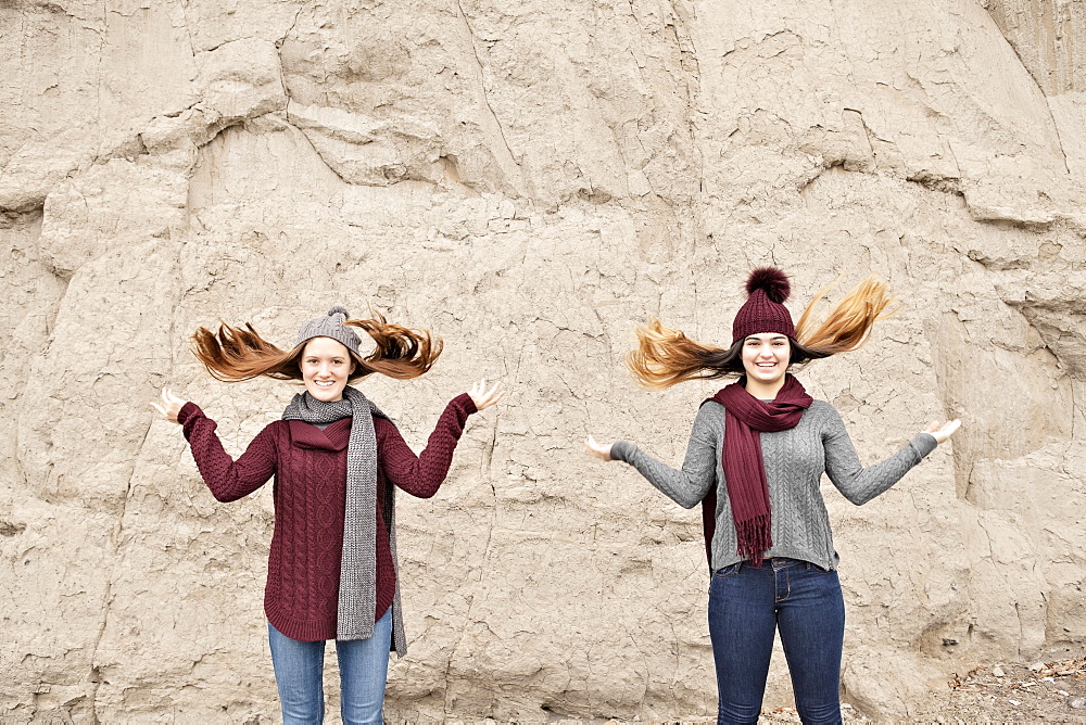 Two friends standing in front of the Scarborough Bluffs and flipping hair up, Scarborough, Ontario, Canada