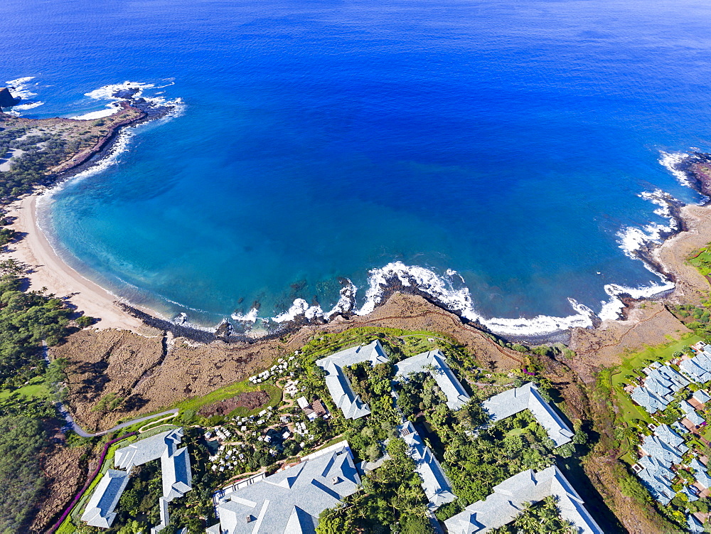 An aerial view of the golden beach and palm tree's at Hulopo'e Beach Park, and the Four Seasons resort at Manele Bay, Wailuku, Lanai, Hawaii, United States of America